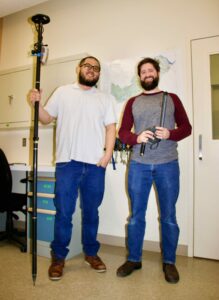 MVCA staff Timothy Yoon holding a GPS measuring device and Daniel Post